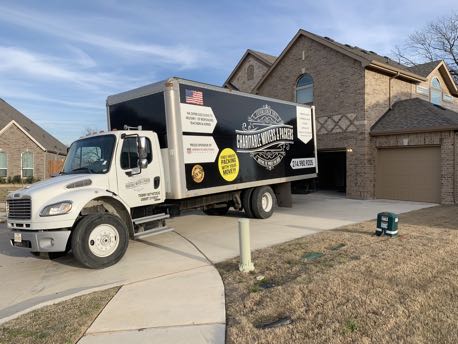 Image: Charitable Mover & Packers moving truck parked at a house.