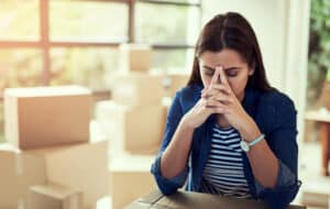Cropped shot of a young woman looking stressed out while moving house